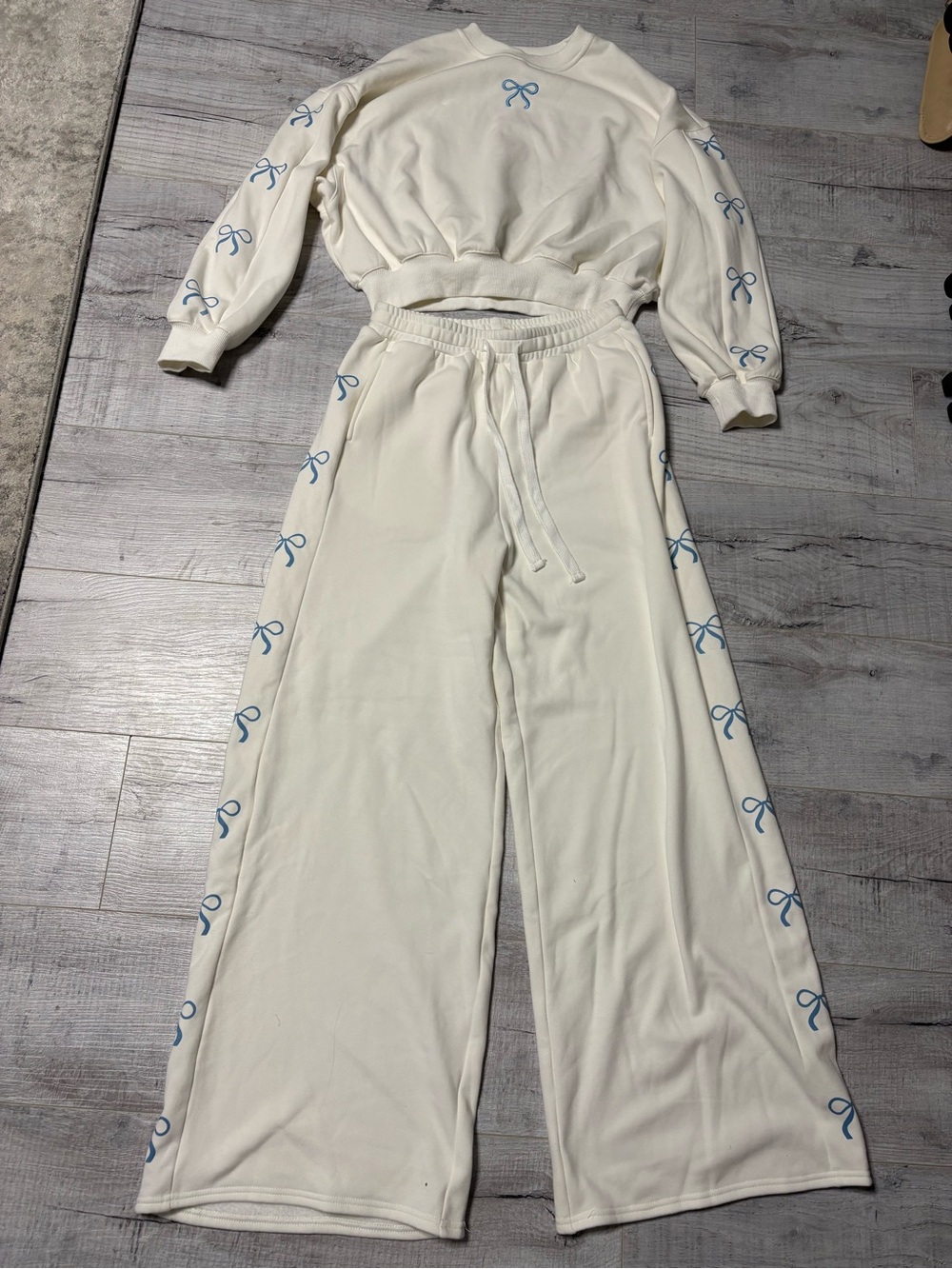 White Wide-Leg Sweatpants with Blue Bow Accent from boutique store
